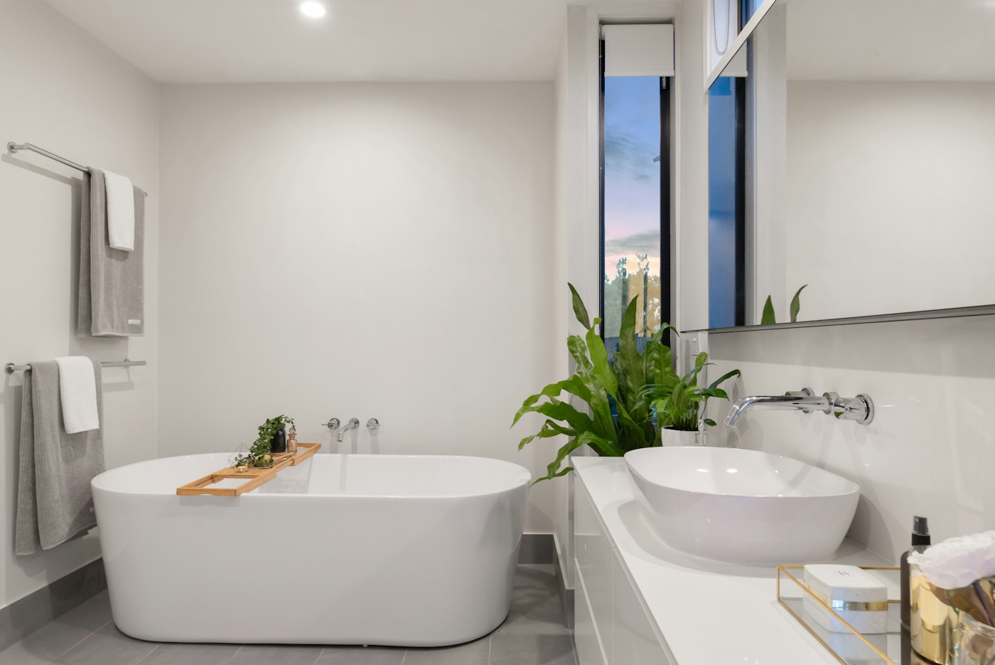 A bright bathroom with a freestanding bathtub and basin